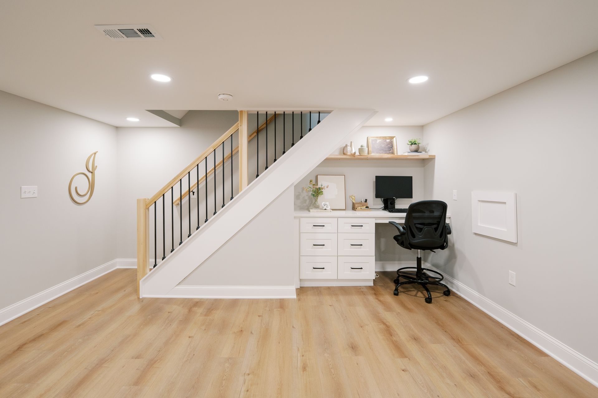 There is a desk under the stairs in the basement.