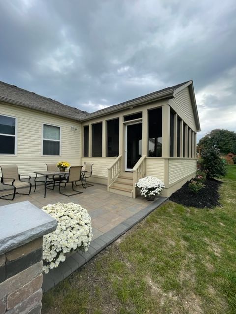A screened in porch with a table and chairs