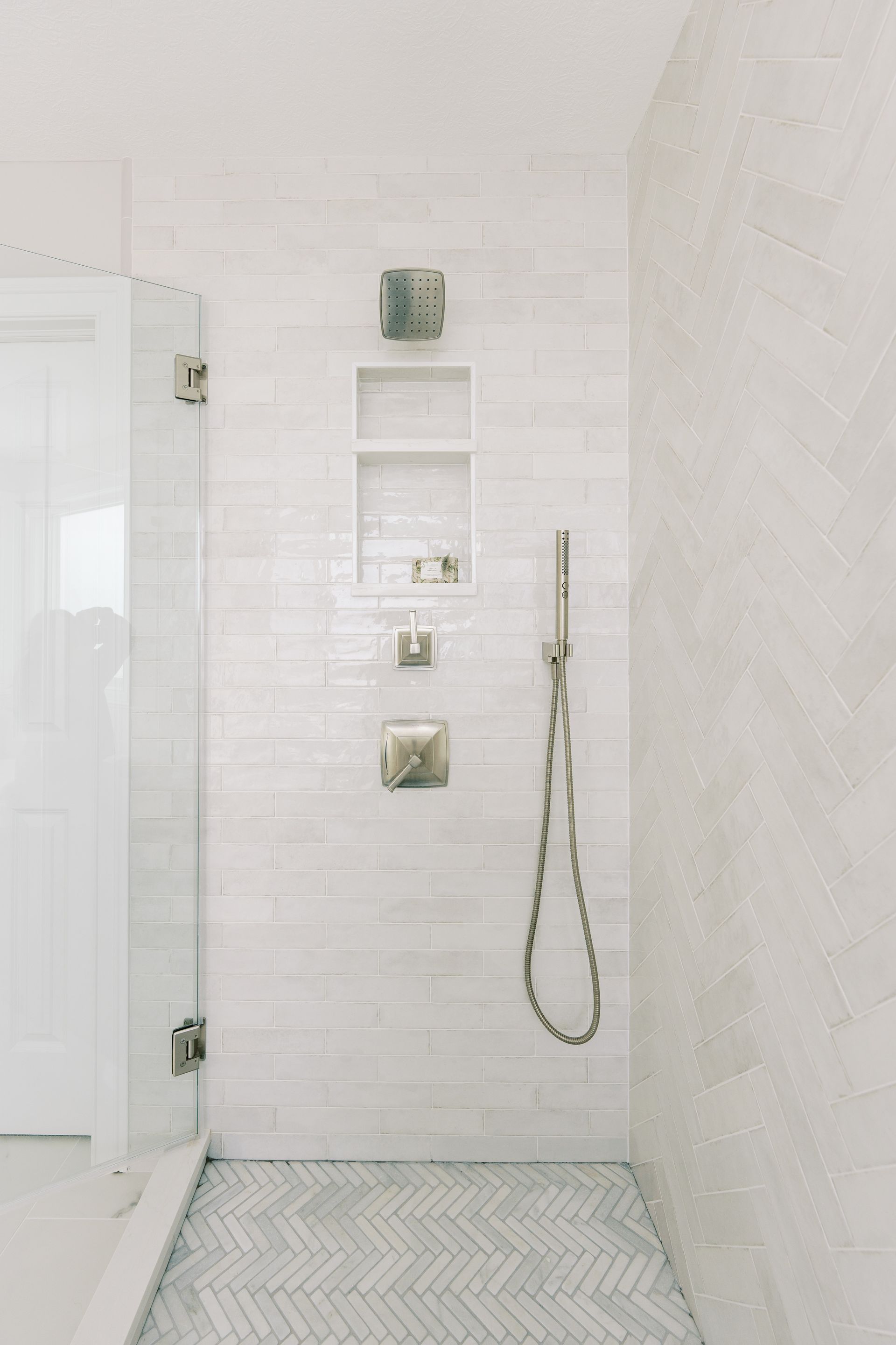 A bathroom with a walk in shower and a glass door.