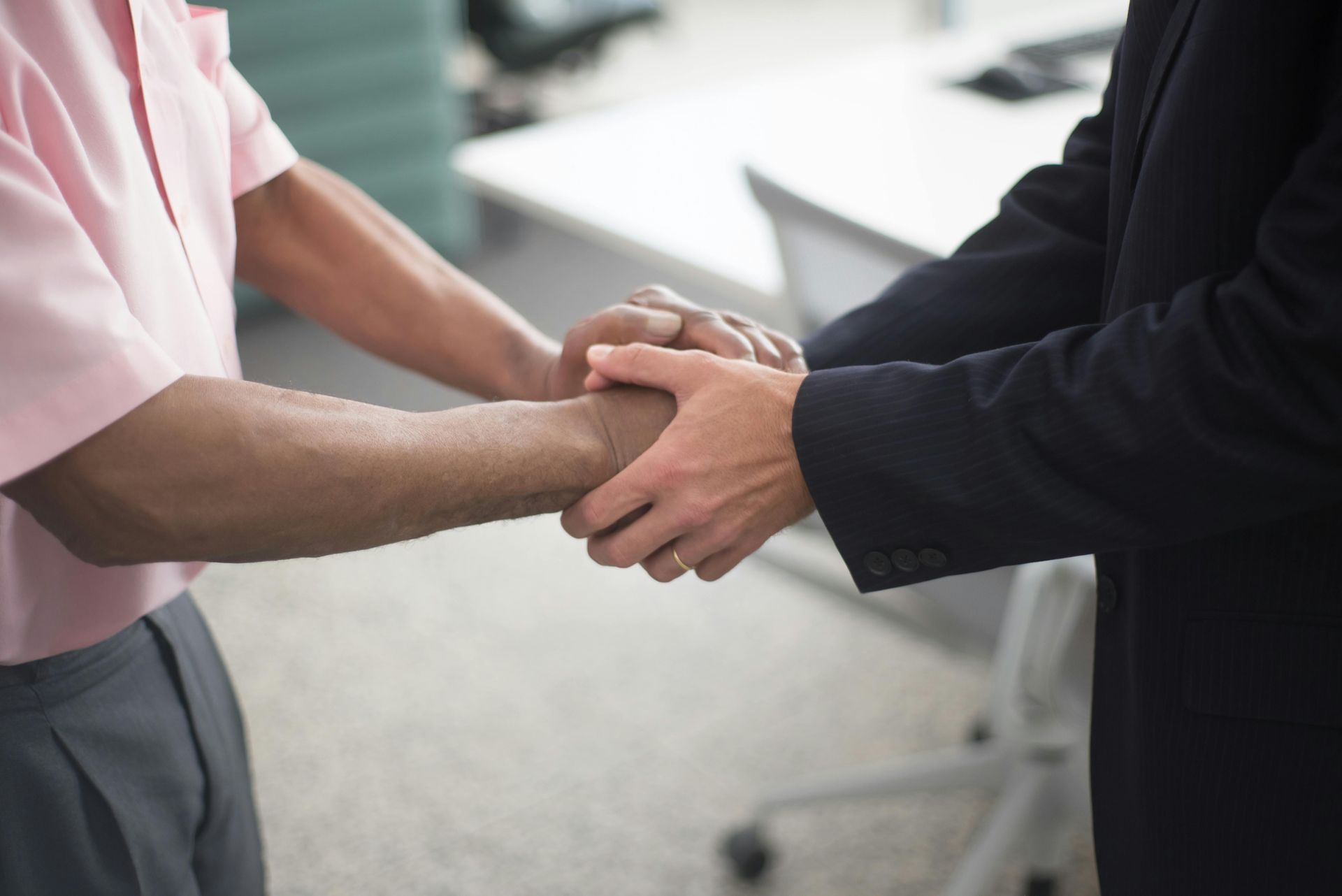 Two men are shaking hands in an office.