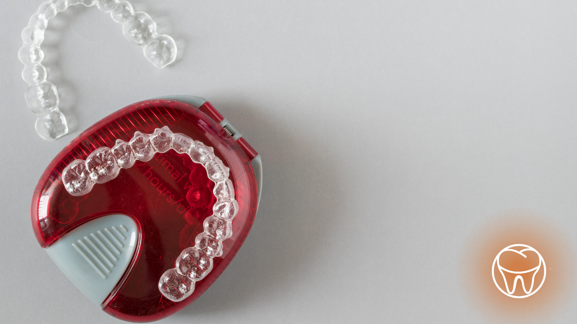 A red case filled with clear braces on a white surface.