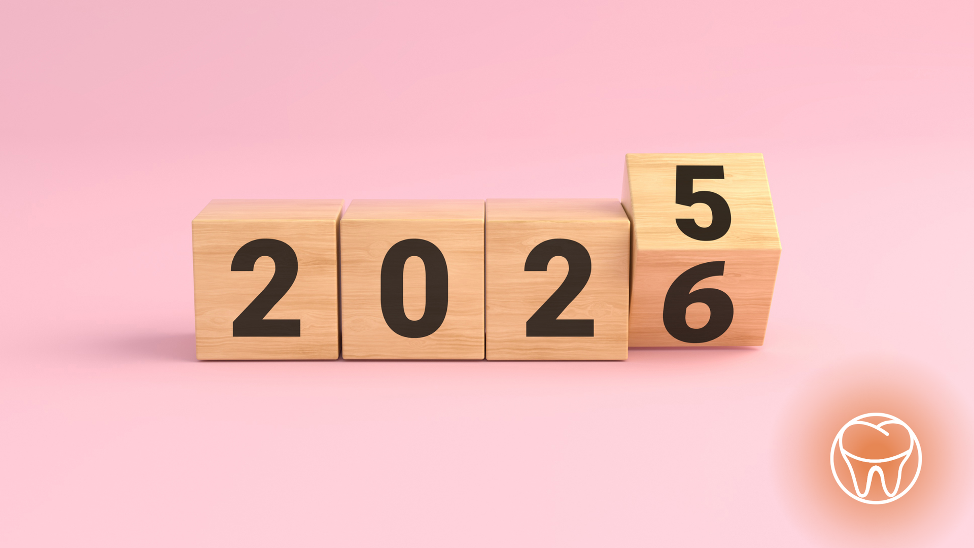 Wooden blocks showing the year 2025 turning into 2026 on a pink surface.