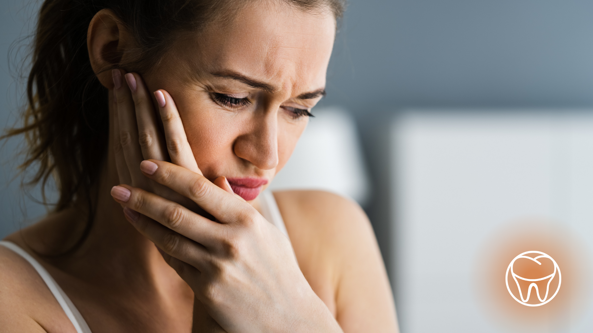 A woman is holding her face in pain because of a toothache.