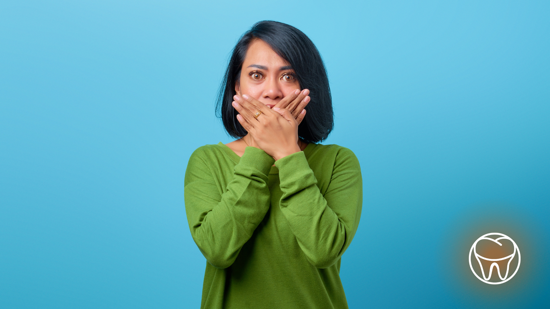 Woman covering mouth with hands, expressing shock, against a blue background.