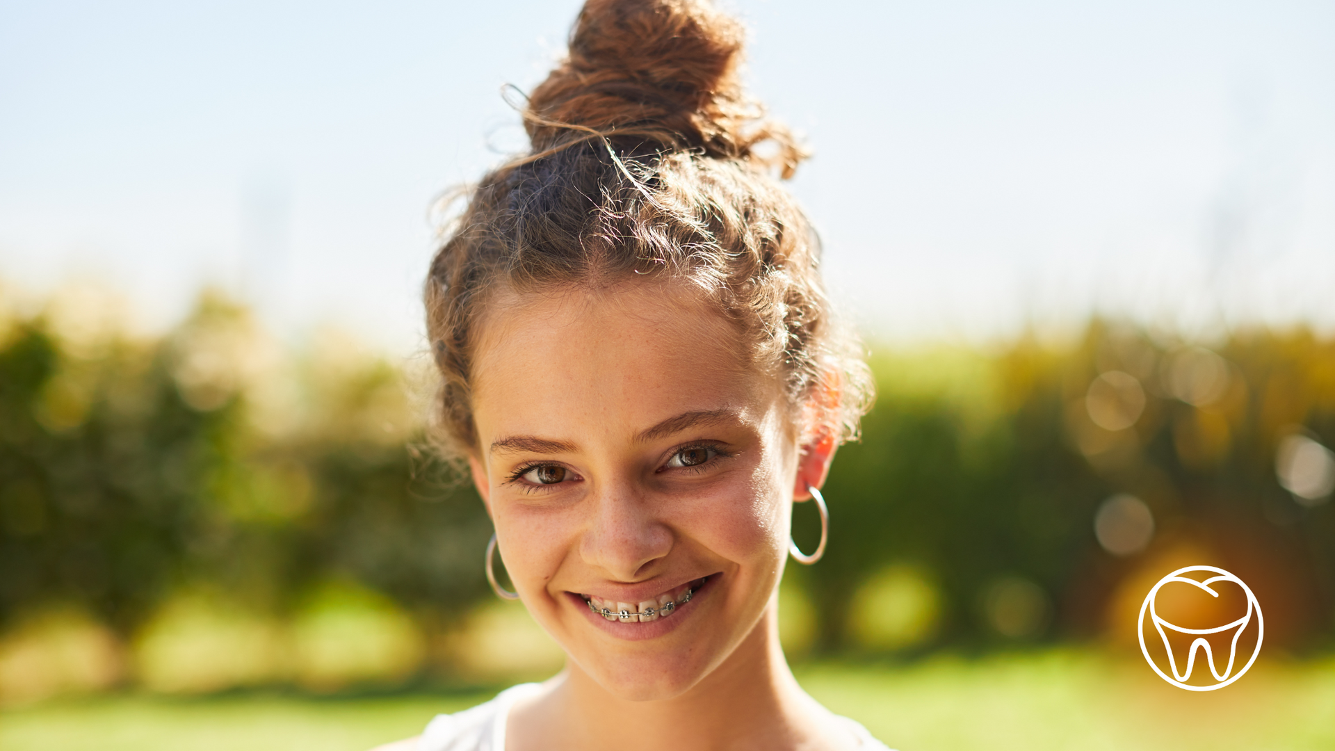 A young girl with braces on her teeth is smiling for the camera.