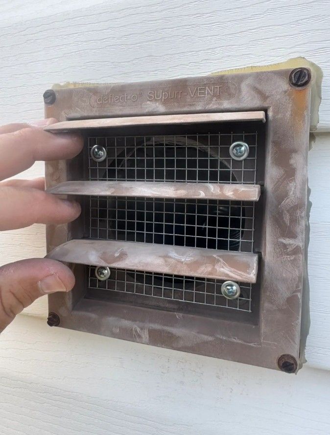 A squirrel is sitting on top of a roof eating a nut.