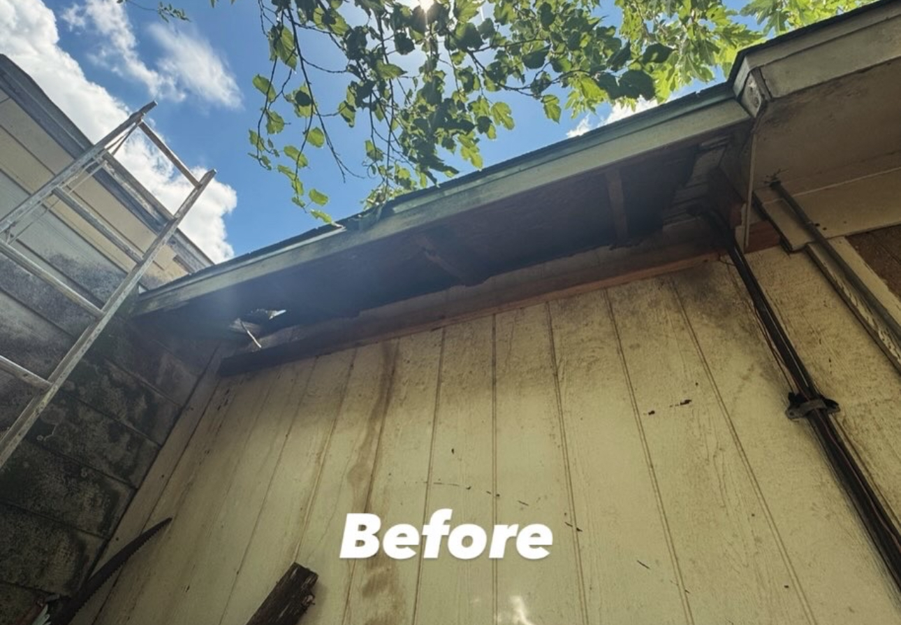 Exterior of building with peeling, moldy siding, with the word 