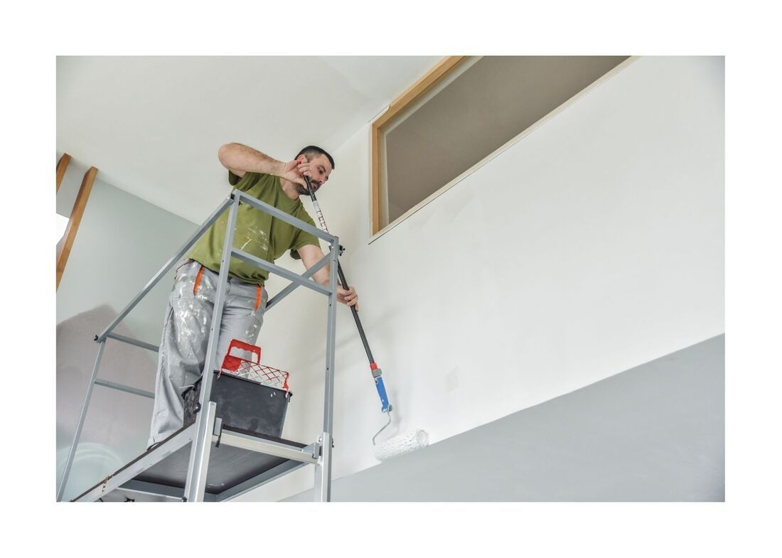 New West Painting employee on ladder painting with extendable roller