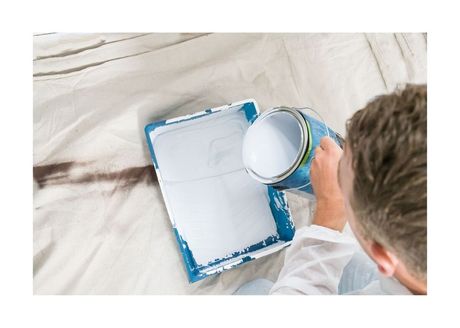 New Westminster Painting Employee poring white paint into painting tray
