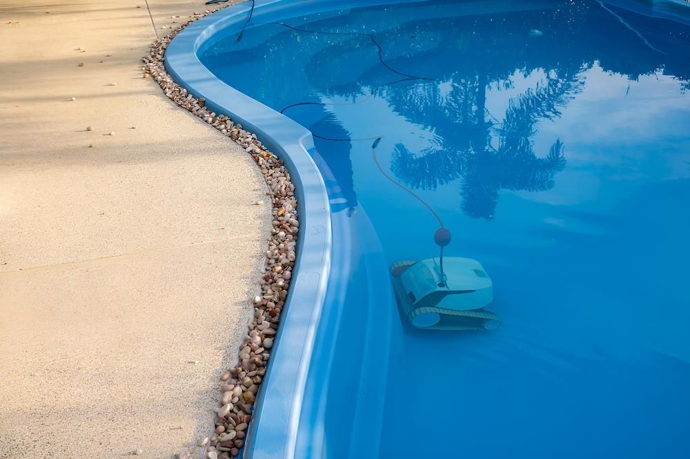 A Robotic Pool Cleaner is Sitting in the Middle of a Swimming Pool — Sun City Pools In Hyde Park, QLD