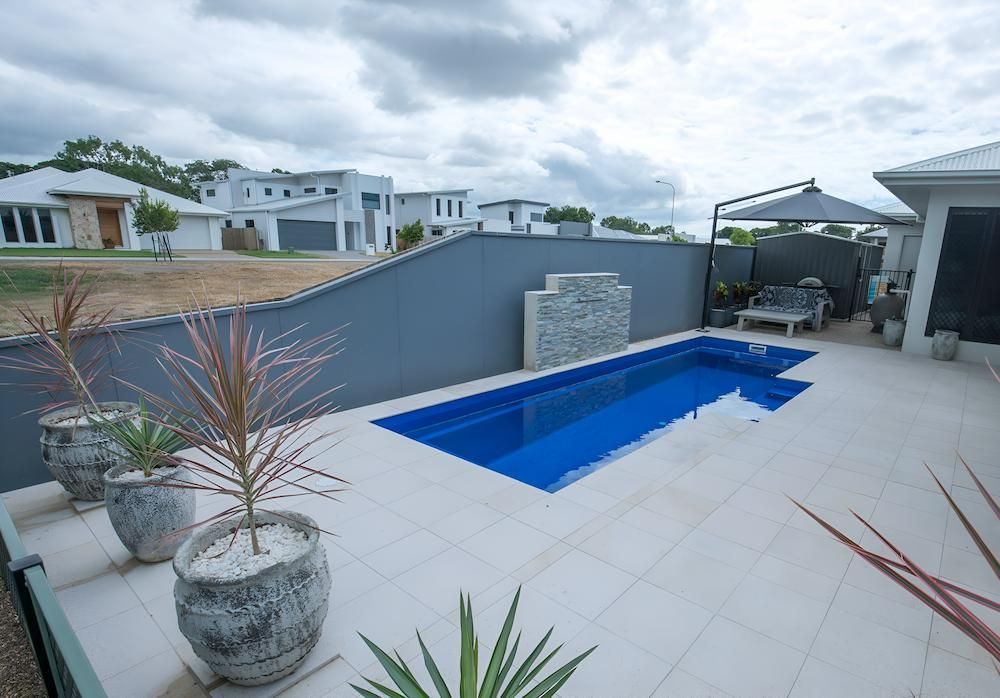 There is a Large Swimming Pool in the Backyard of a House — Sun City Pools In Hyde Park, QLD