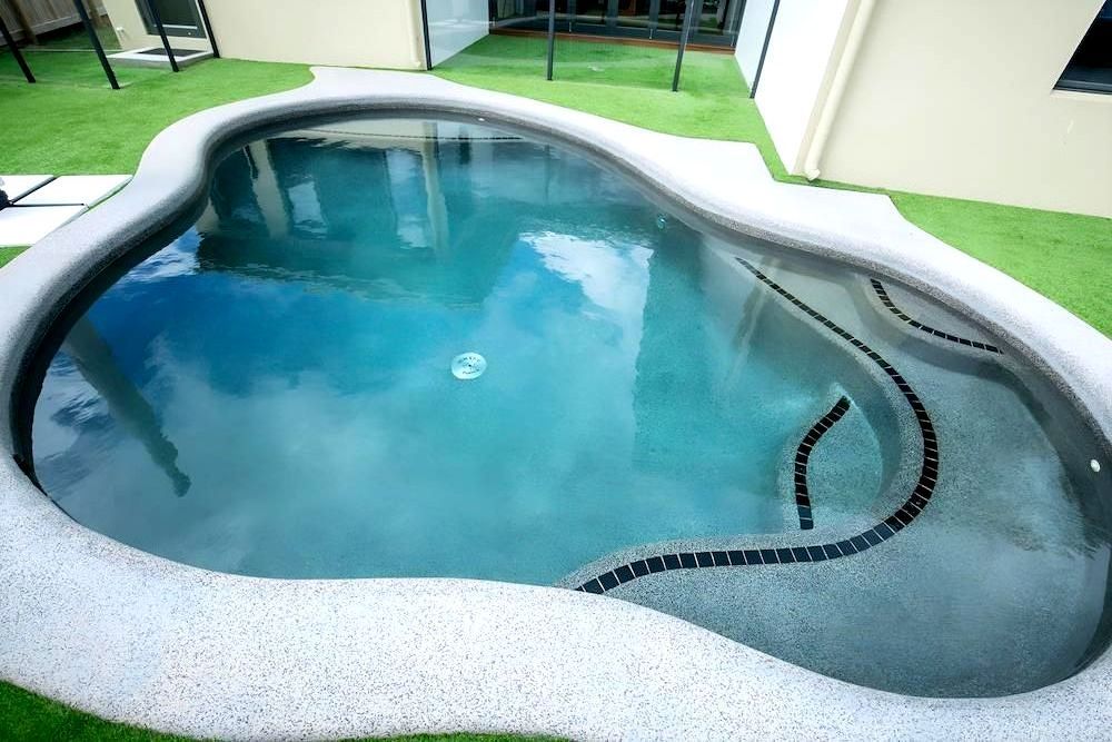 A Large Swimming Pool With a Reflection of Clouds in the Water — Sun City Pools In Hyde Park, QLD