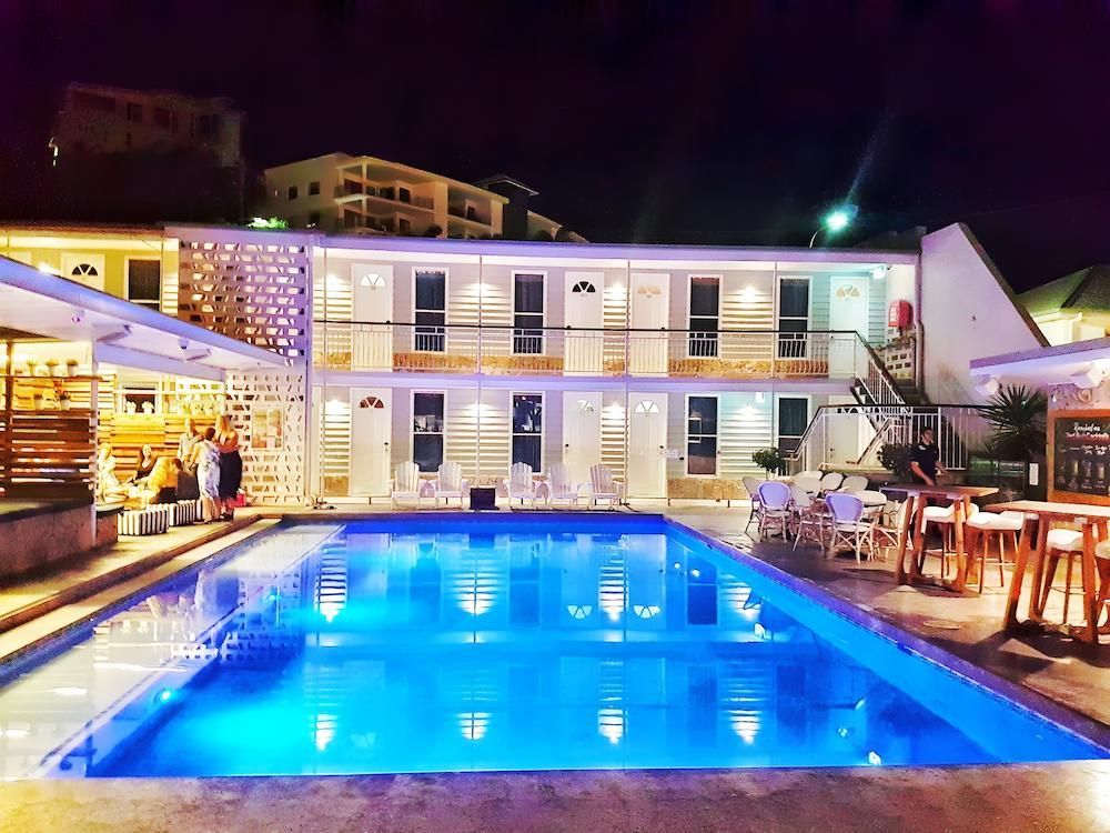 A Large Swimming Pool is in Front of a Hotel at Night — Sun City Pools In Hyde Park, QLD
