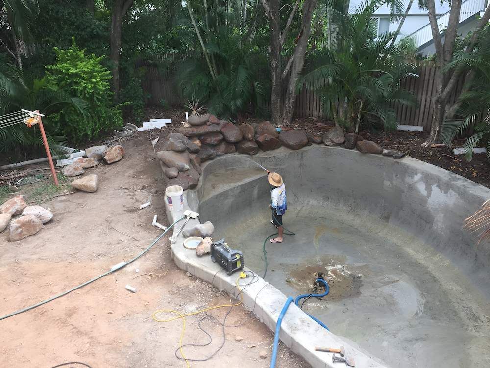 A Person is Working on a Swimming Pool in a Backyard — Sun City Pools In Hyde Park, QLD