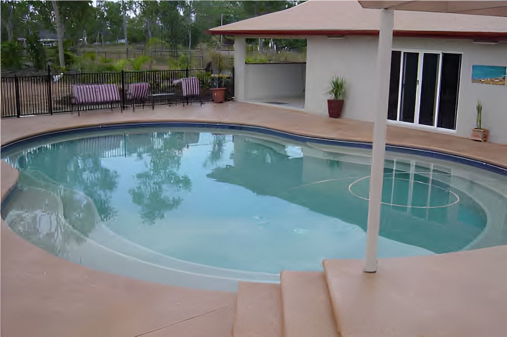 A Large Swimming Pool in Front of a House — Sun City Pools In Hyde Park, QLD