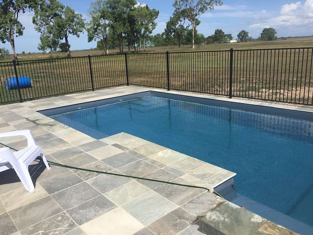 A Person is Pouring Chlorine Into a Swimming Pool — Sun City Pools In Hyde Park, QLD