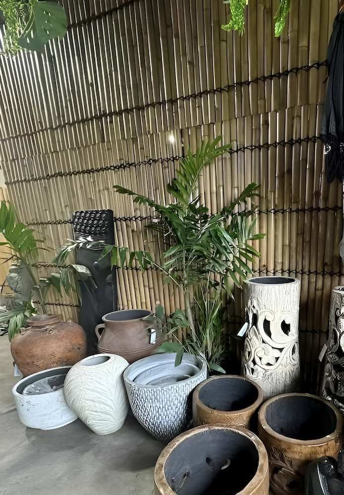 A Bunch of Pots Are Sitting on a Table in Front of a Bamboo Wall — Sun City Pools In Hyde Park, QLD
