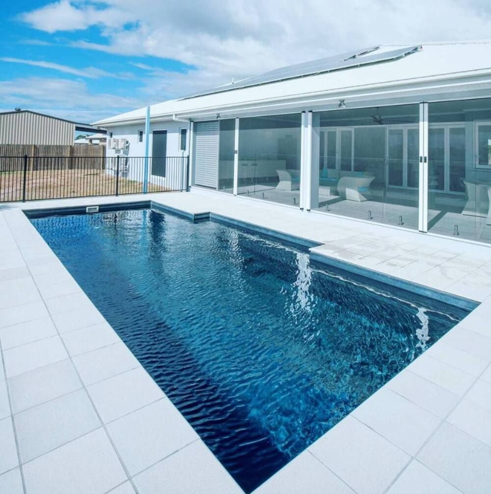 A Large Swimming Pool in Front of a House — Sun City Pools In Hyde Park, QLD