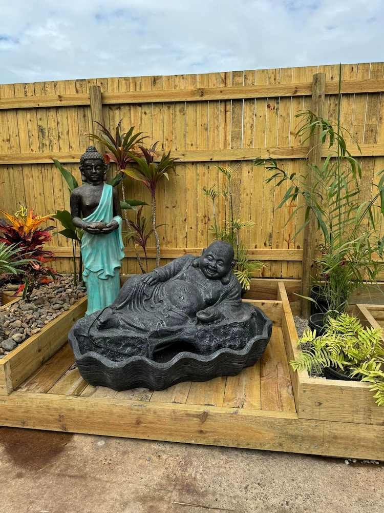 One Green Statue Standing Beside the Black Buddha — Sun City Pools In Hyde Park, QLD