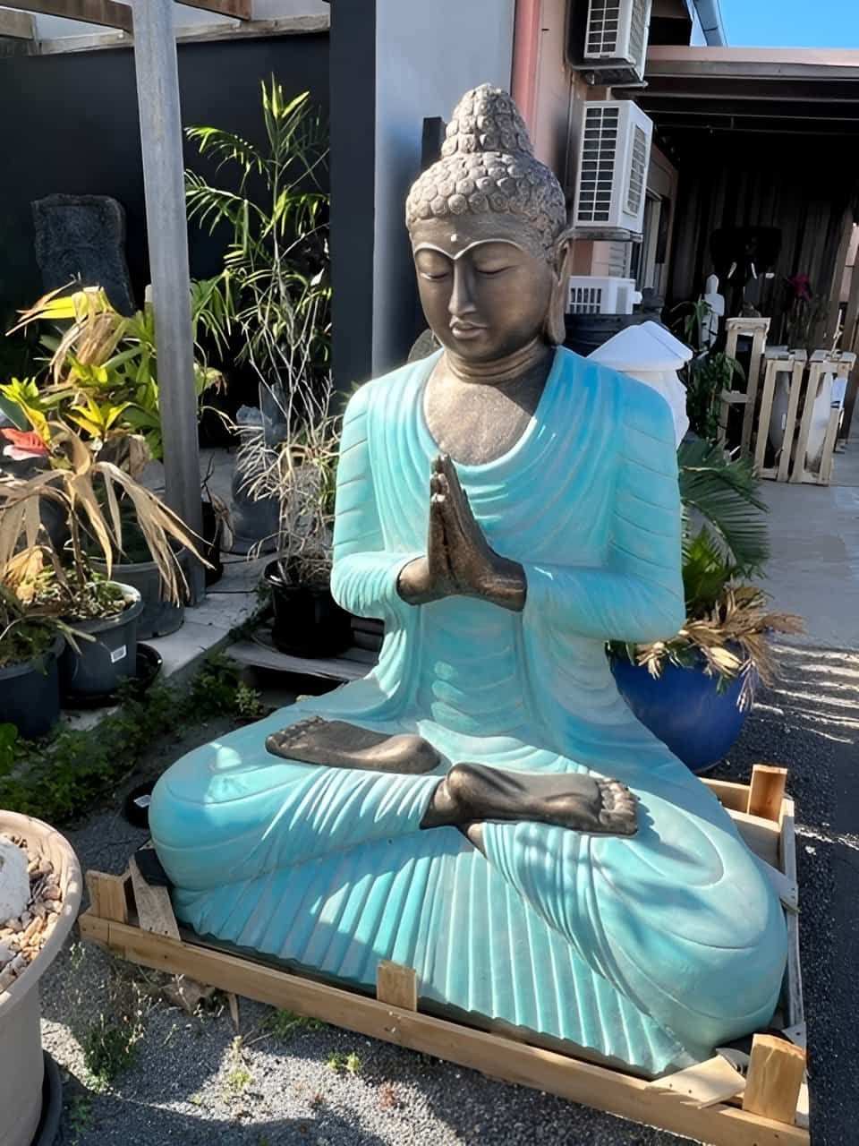 A Blue Girl Statue Sitting on a Stone With Plants Behind — Sun City Pools In Hyde Park, QLD