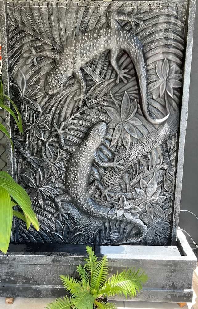 A Fountain With a Lizard Carved Into It is Sitting Next to a Plant — Sun City Pools In Hyde Park, QLD