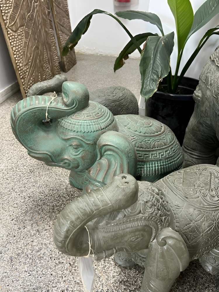 A Group of Elephant Statues Are Sitting on a Carpet Next to a Potted Plant — Sun City Pools In Hyde Park, QLD