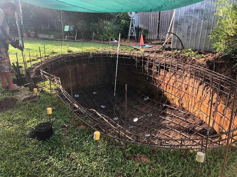 A Man is Digging a Hole in the Ground to Build a Swimming Pool — Sun City Pools In Kirwan, QLD