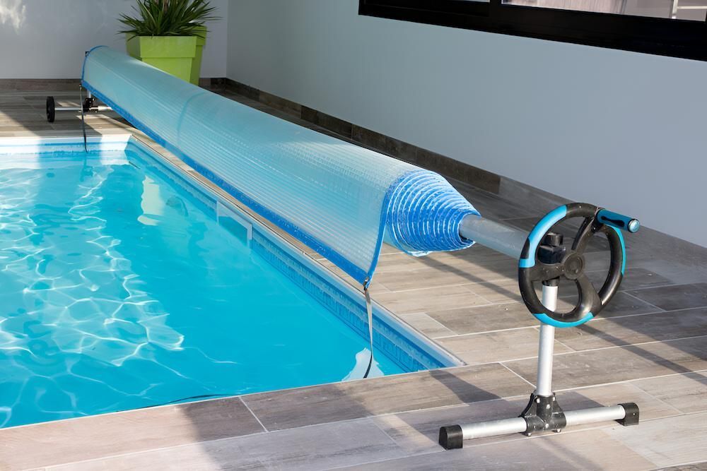 A Swimming Pool With a Solar Blanket on the Side of It — Sun City Pools In Hyde Park, QLD