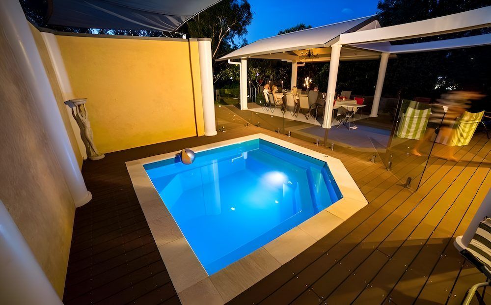 A Small Swimming Pool is Surrounded by a Wooden Deck — Sun City Pools In Hyde Park, QLD