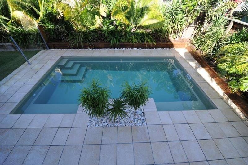 A Swimming Pool Surrounded by Palm Trees and Tiles — Sun City Pools In Hyde Park, QLD