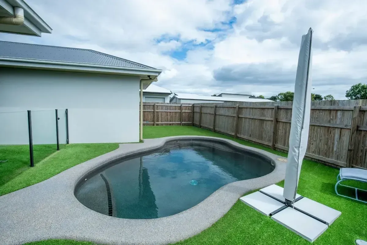 A Large Swimming Pool With a View of a City and Mountains — Sun City Pools In Hyde Park, QLD