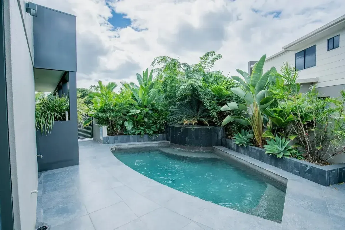 There is a Large Swimming Pool in the Backyard of a House — Sun City Pools In Hyde Park, QLD