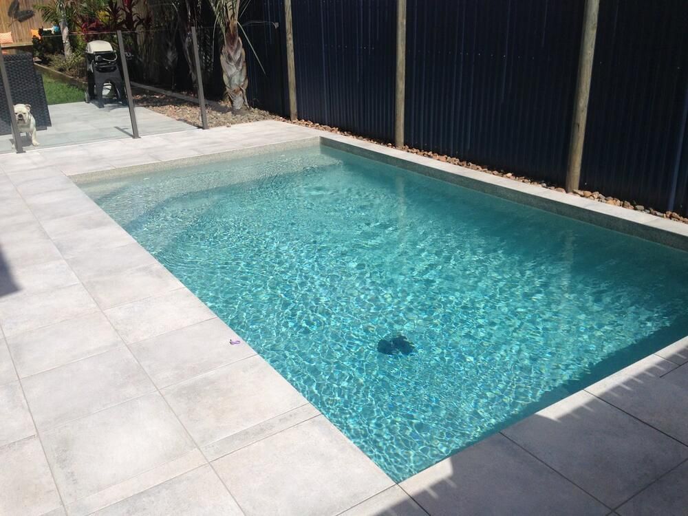 A Large Swimming Pool With a Staircase Leading to It — Sun City Pools In Hyde Park, QLD