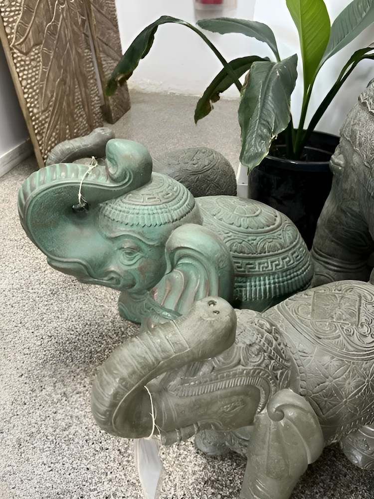 Three Elephant Statues Are Sitting on a Carpet Next to Potted Plants — Sun City Pools In Hyde Park, QLD