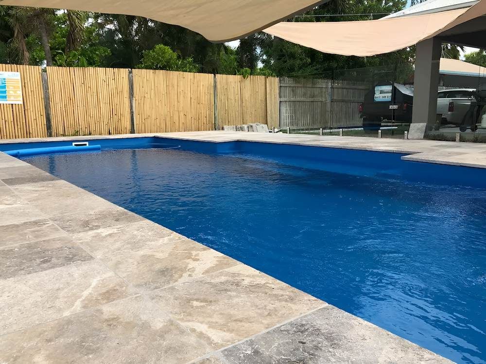 A Swimming Pool Surrounded by Rocks and a Statue of an Angel — Sun City Pools In Hyde Park, QLD