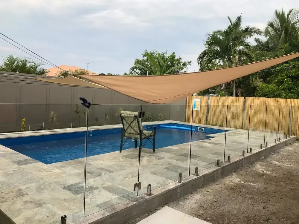 A Swimming Pool With a Chair and Umbrella in Front of It — Sun City Pools In Hyde Park, QLD