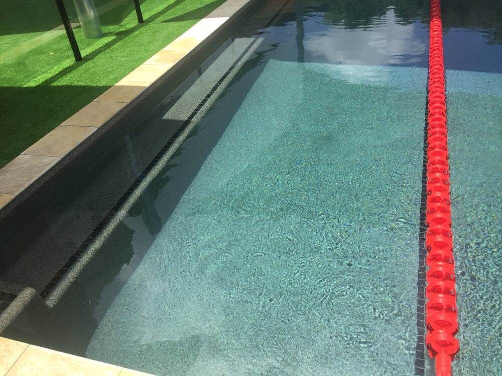 A Swimming Pool With a Red Lane in the Middle of It — Sun City Pools In Hyde Park, QLD