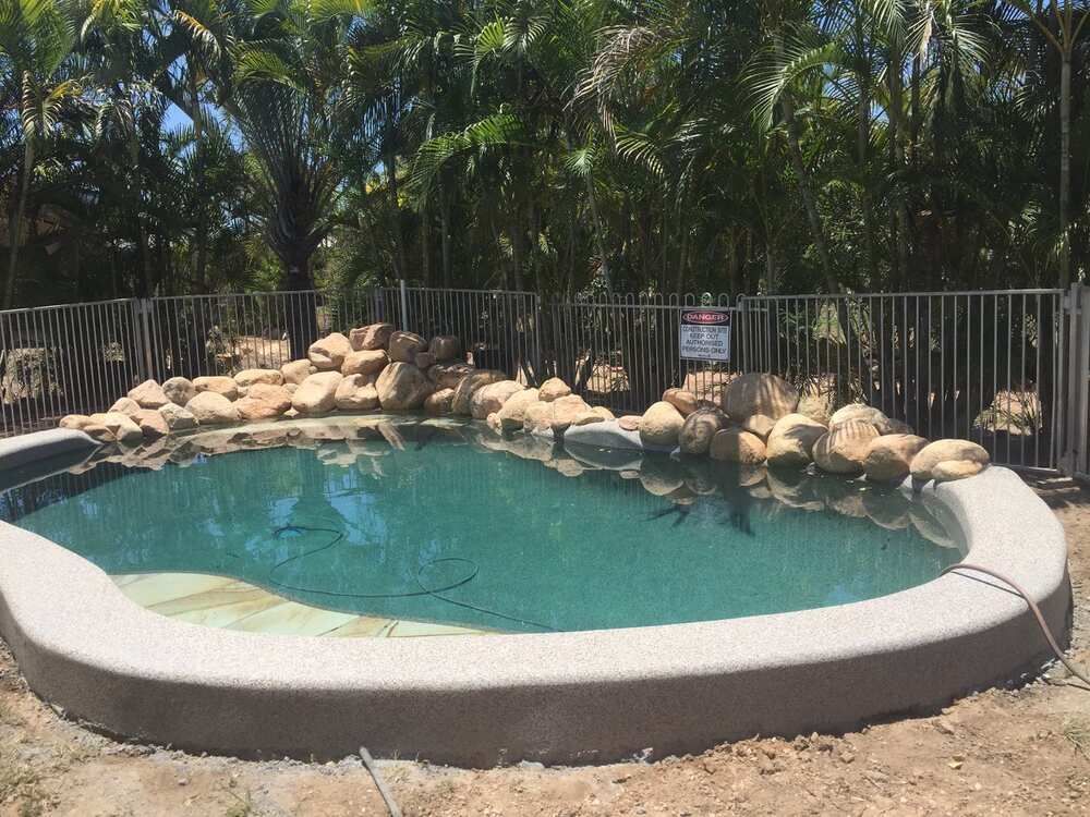 A Large Swimming Pool With a Fence Around It — Sun City Pools In Hyde Park, QLD
