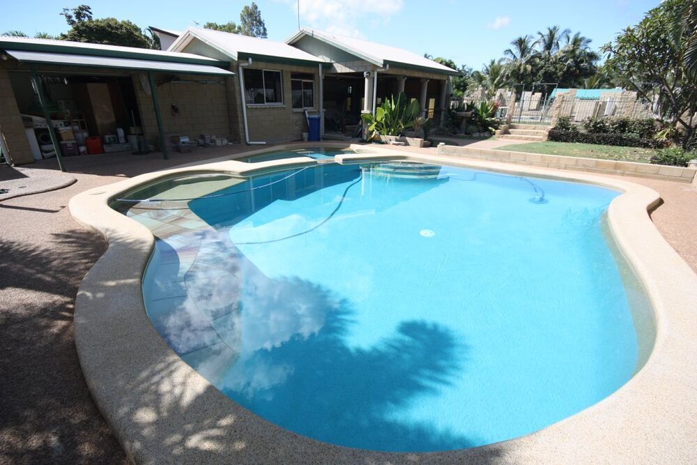 A Large Swimming Pool in Front of a House — Sun City Pools In Hyde Park, QLD