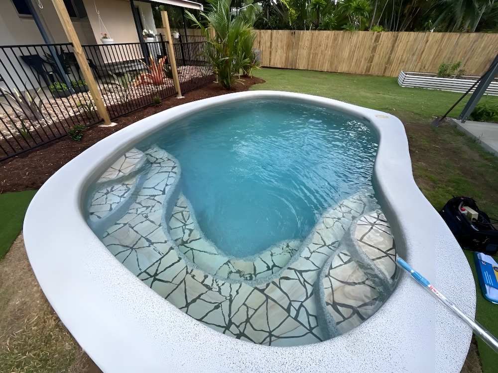 A Small Swimming Pool is Sitting in the Backyard of a House — Sun City Pools In Hyde Park, QLD