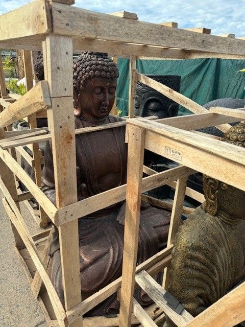 A Statue of a Woman is Sitting in Front of a Bamboo Fence — Sun City Pools In Hyde Park, QLD