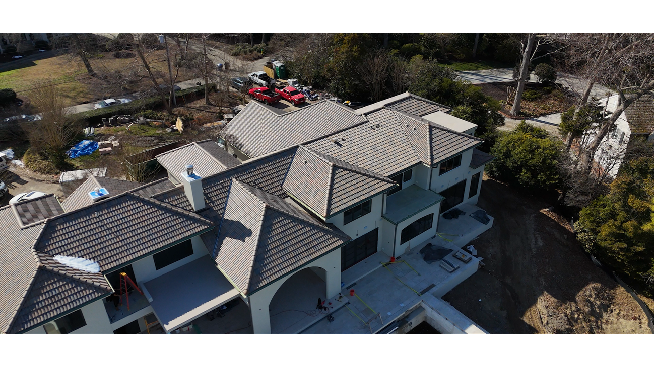 A construction worker is working on the roof of a building.
