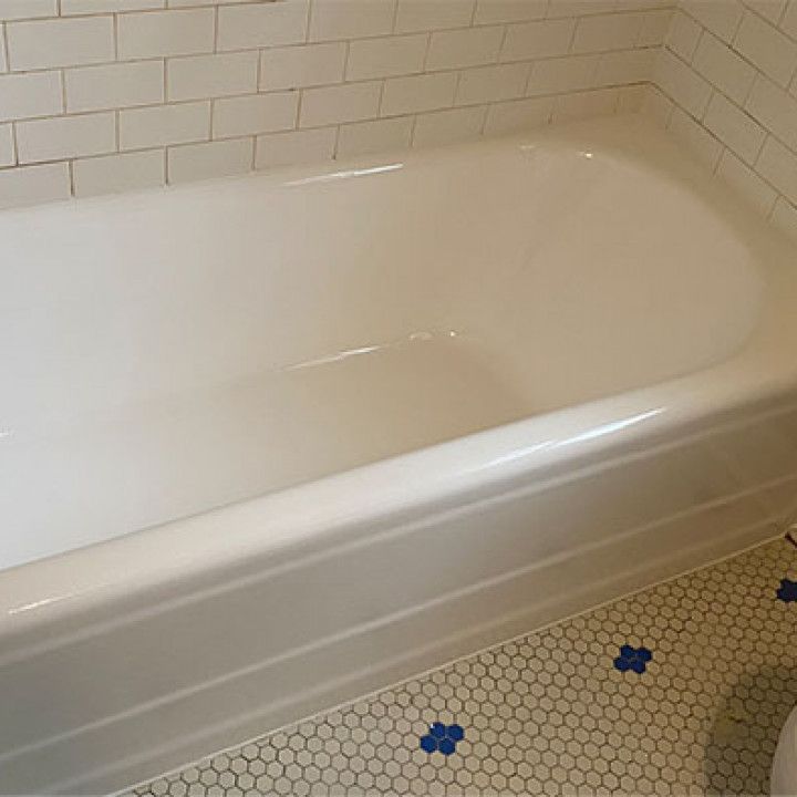 A white bathtub is sitting in a bathroom next to a toilet.