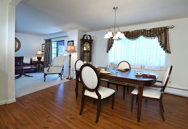 A dining room with a table and chairs and a grandfather clock