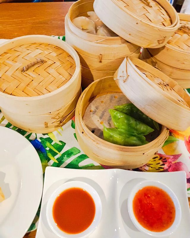 Bunch of Bamboo Steamers Filled With Food and Sauces on a Table — Heritage Resort in Nanum, QLD