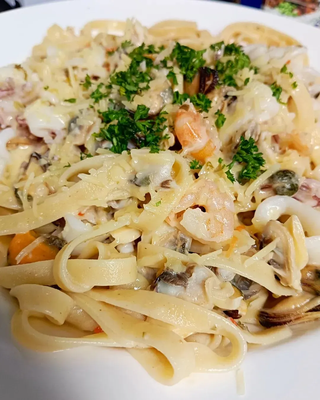 A Close Up Of A Plate Of Pasta With Seafood And Cheese On A Table — Heritage Resort in Nanum, QLD