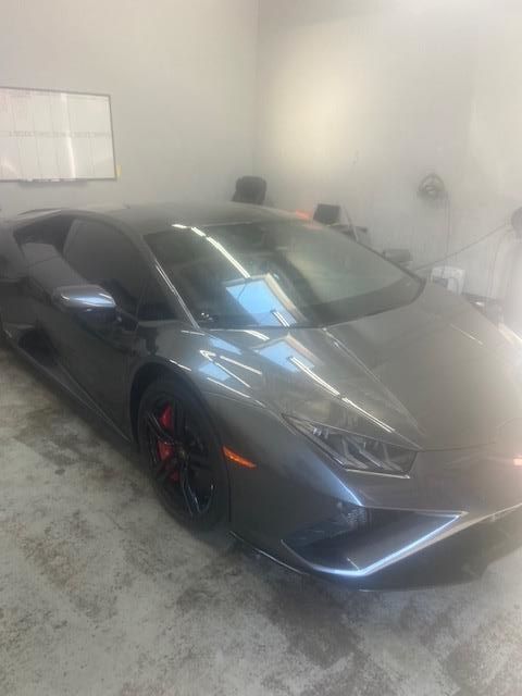 Dark gray Lamborghini in a brightly lit garage.