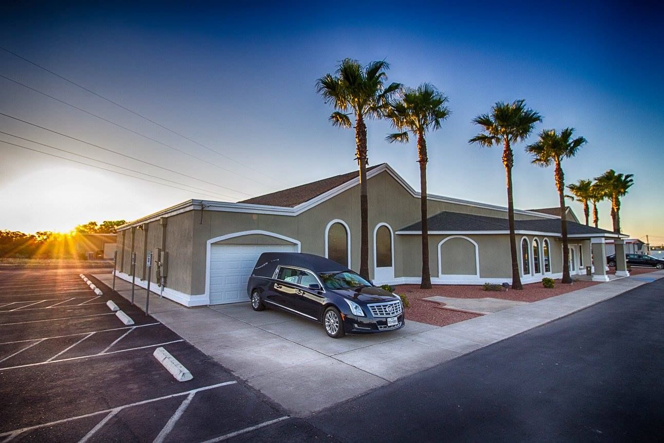Single-story house with palm trees and a parked car at sunset