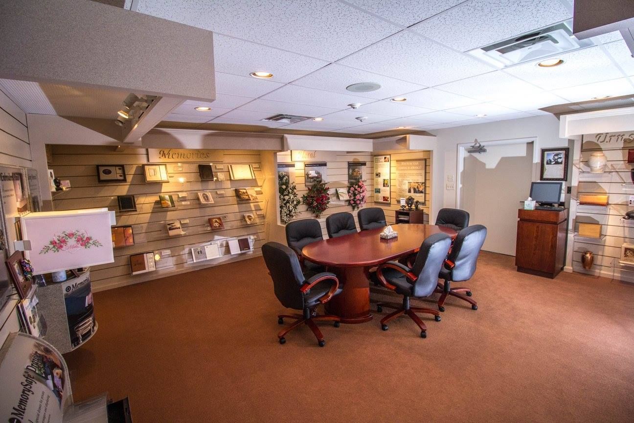 Room with a large table, swivel chairs, and wall shelves in a warm-toned office space