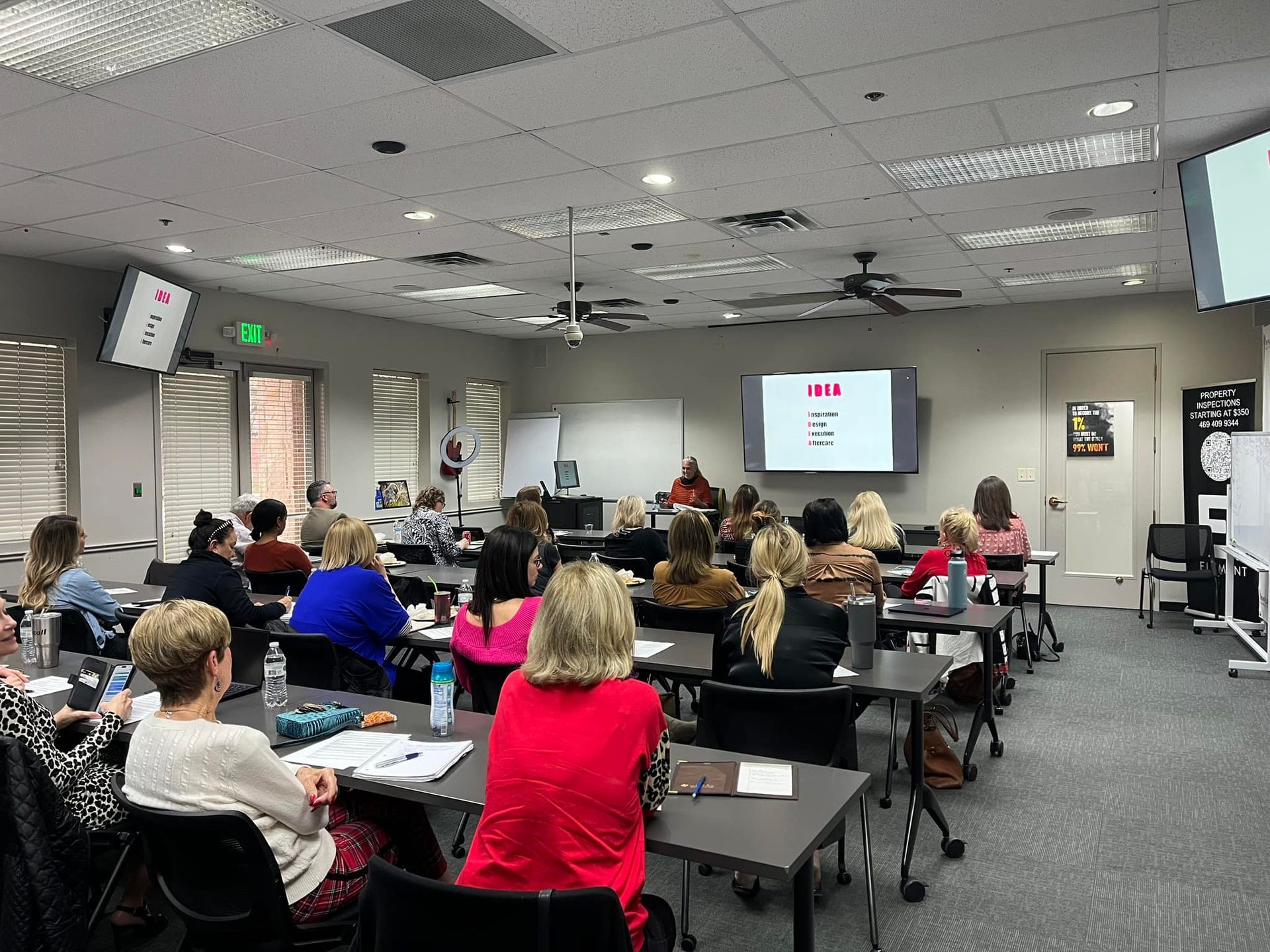 A group of people are sitting at tables in a large room.
